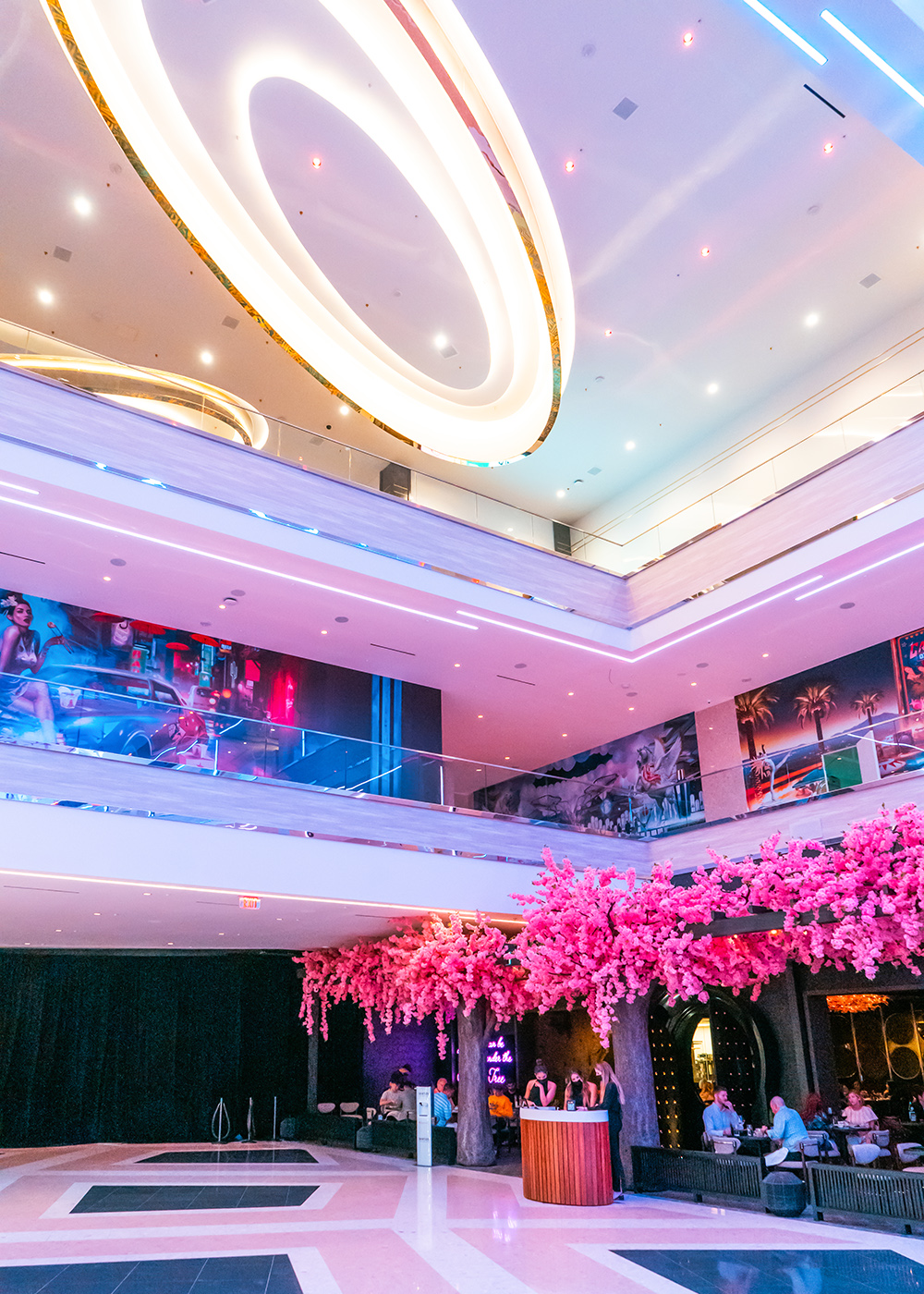 Resorts World Las Vegas interior with circular ceiling lighting and a pink floral installation