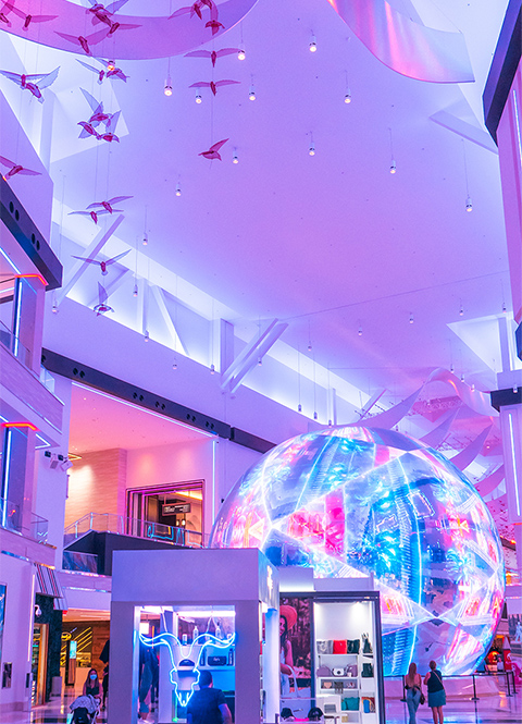 The Globe at Resorts World Las Vegas with vibrant color-changing lighting in The District